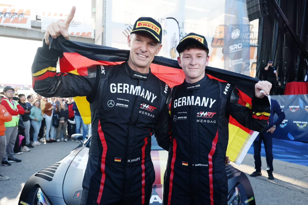 Zwei Rennfahrer im Team-Germany-Rennanzug jubeln mit der Deutschlandfahne